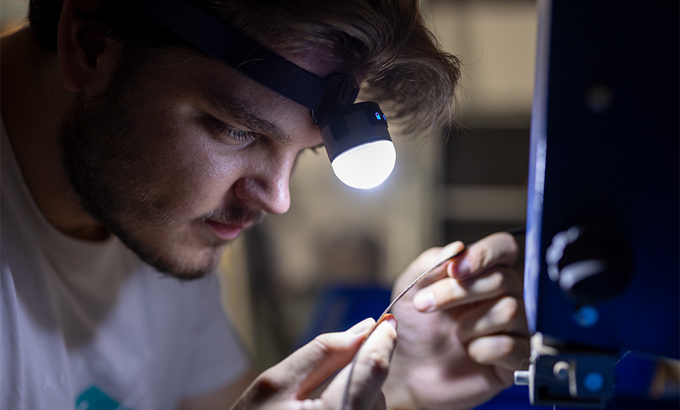 REEVES lampen als promotieartikelen Werkende man met een REEVES-hoofdlamp in de werkplaats