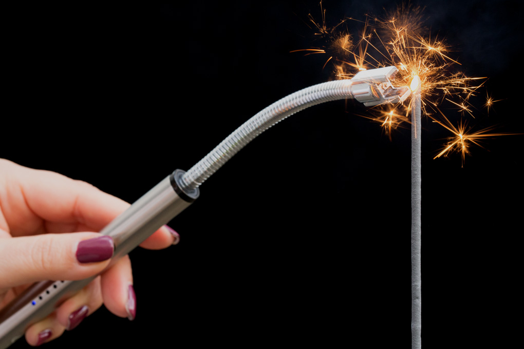 Lichtbogenstabfeuerzeug als weihnachtliches Werbegeschenk anzuenden einer Wunderkerze mit Lichtbogenfeuerzeug