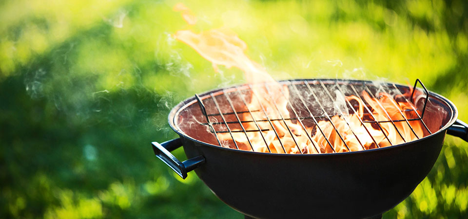 Grillzubehör als Werbeartikel Leerer Grill mit Feuer auf der Wiese