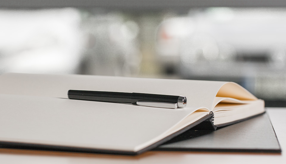 Instruments d'écriture en tant qu'articles promotionnels Un stylo CLIC CLAC sur un carnet ouvert