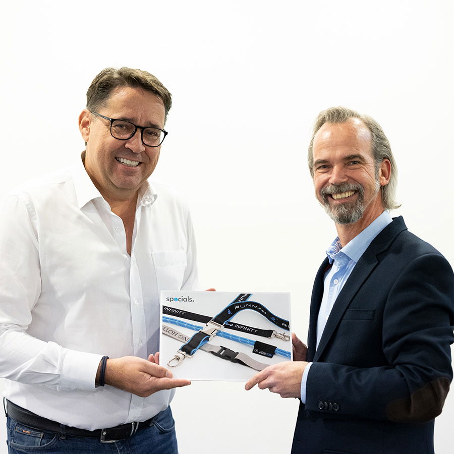 Managing Director Meinhard Mombauer and Dirk Haynberg with lanyard catalogue Managing Director of REFLECTS® and aditan® with lanyard catalogue