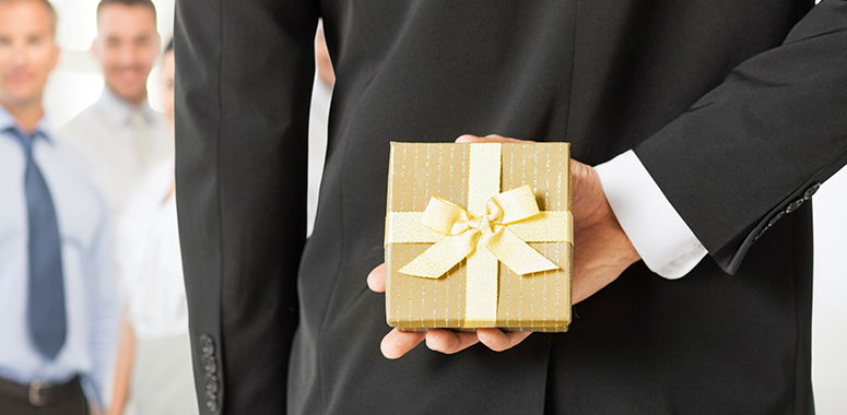 Geschenk hinter Ruecken versteckt
