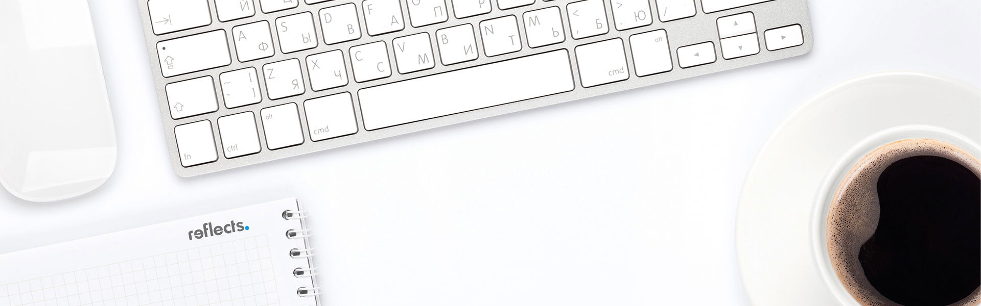 weißer Schreibtisch mit Tastatur und Kaffeetasse