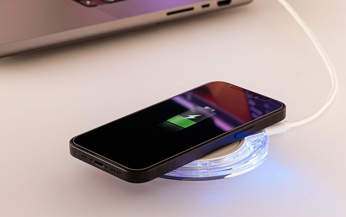 Wireless Charger mit aufladendem Handy und blauem leuchtendem LED-Licht