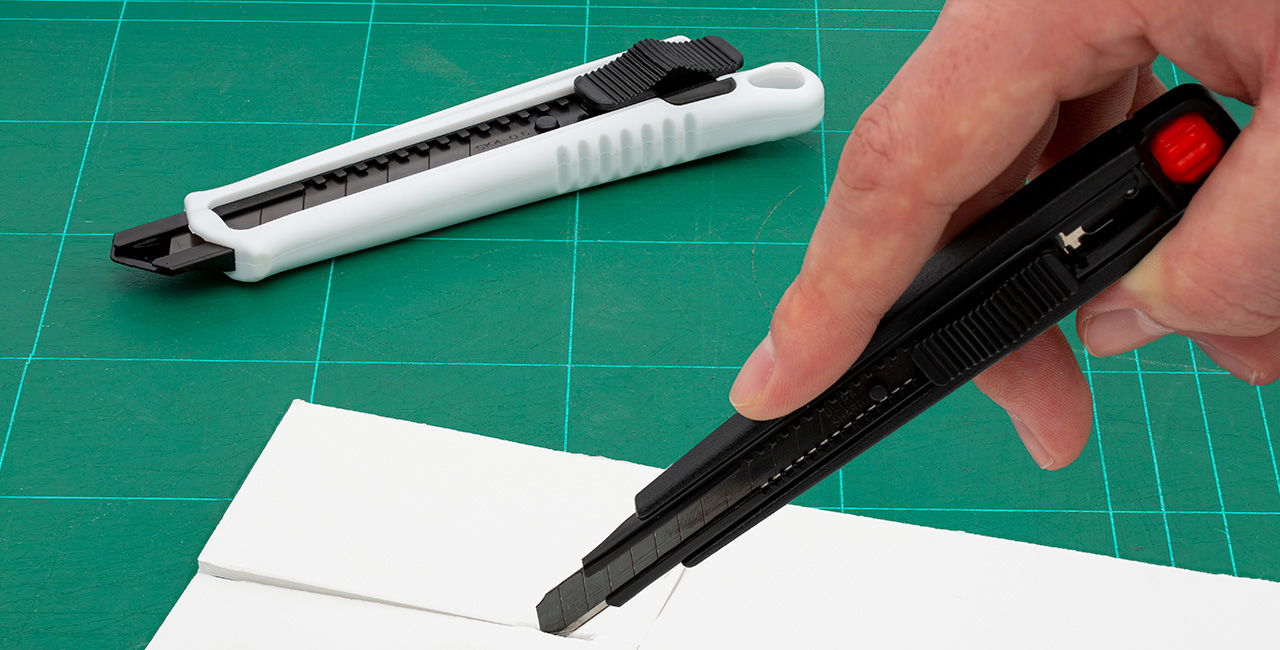 Promotional novelties - Cutter white and black Cutter knife black and white on green cutting mat